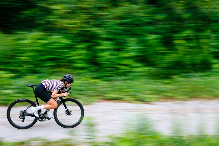 Woman cyclist tucking in an aero position.