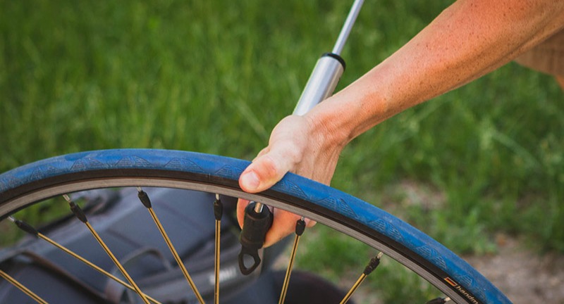 Person airing up a bicycle tire