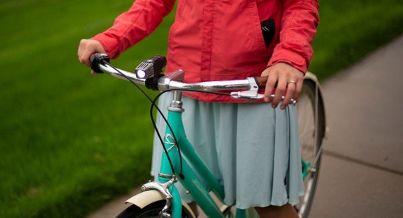 A woman standing over her bike.