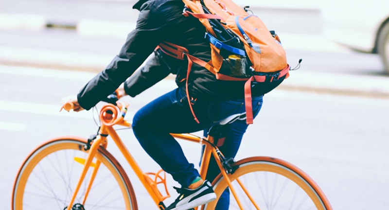 Person riding orange commuter bike