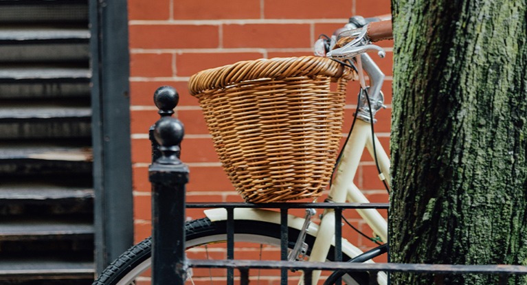 A bike with a wicker basket.