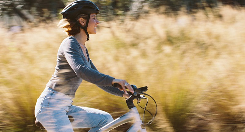 A person riding a Specialized Como E-bike through an autumn field.