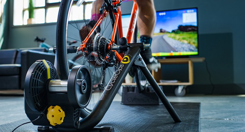 A person riding on an indoor roller trainer