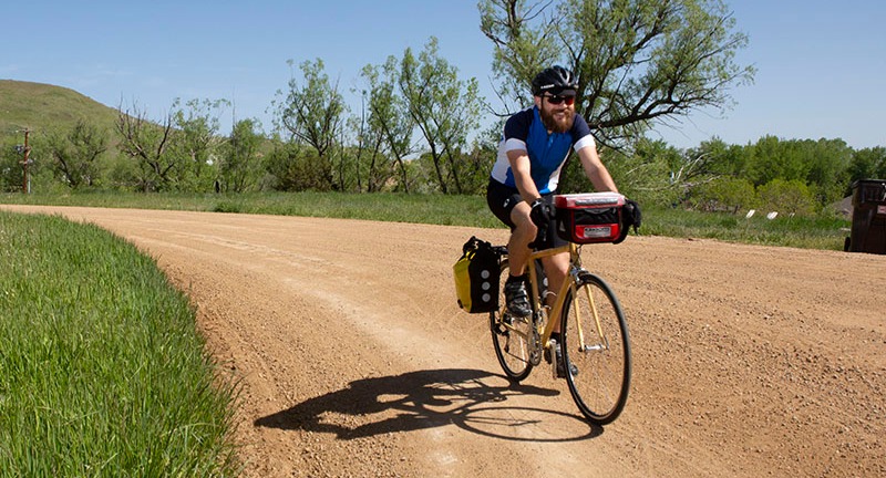 A person riding a bike on a gravel road