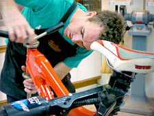 A mechanic adding handlebars to a bike.