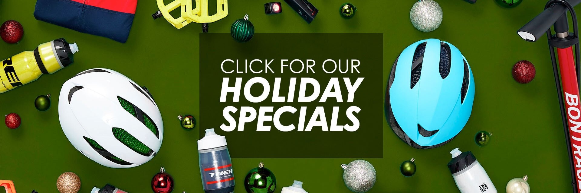 A graphic that reads "click for our holiday specials" with a photo of helmets and tree ornaments scattered around a green background.
