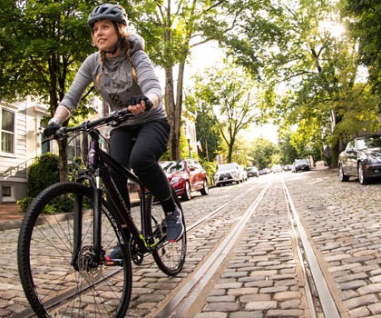 Woman riding a Cannondale bike on cobblestone street