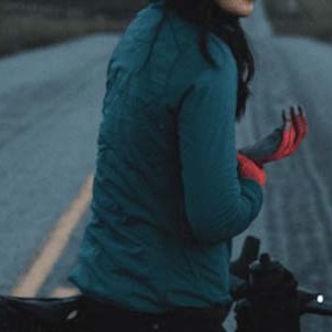 A woman on a bike wearing a Specialized long sleeve bike jersey