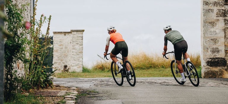 2 riders on a Specialized Roubaix road bike in the street