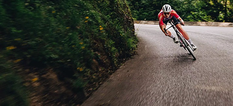 A bike rider resting on a Cannondale Synapse Carbon bike on the road