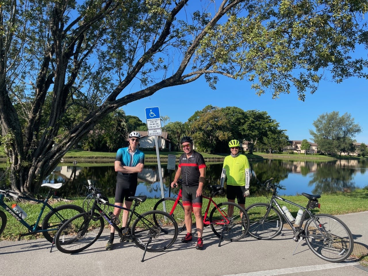 3 people pose with their Trek hybrid and road bikes next to a waterway in Florida.o 