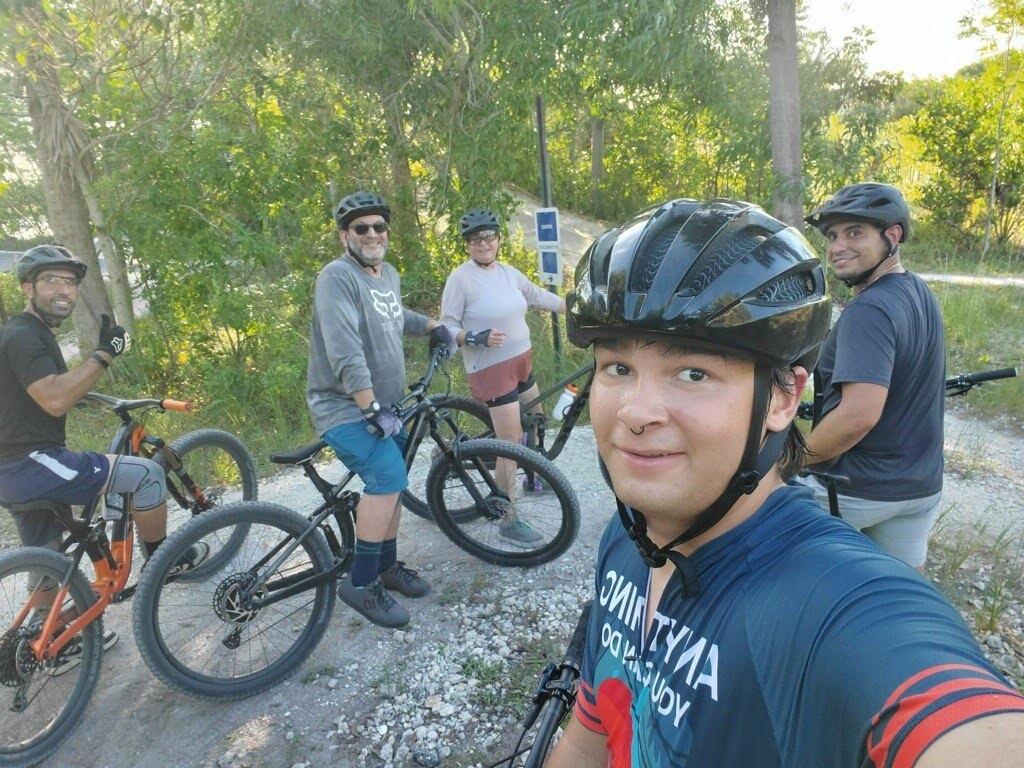 Five people take a selfie with their mountain bikes on the Quiet Waters Trail in Broward County