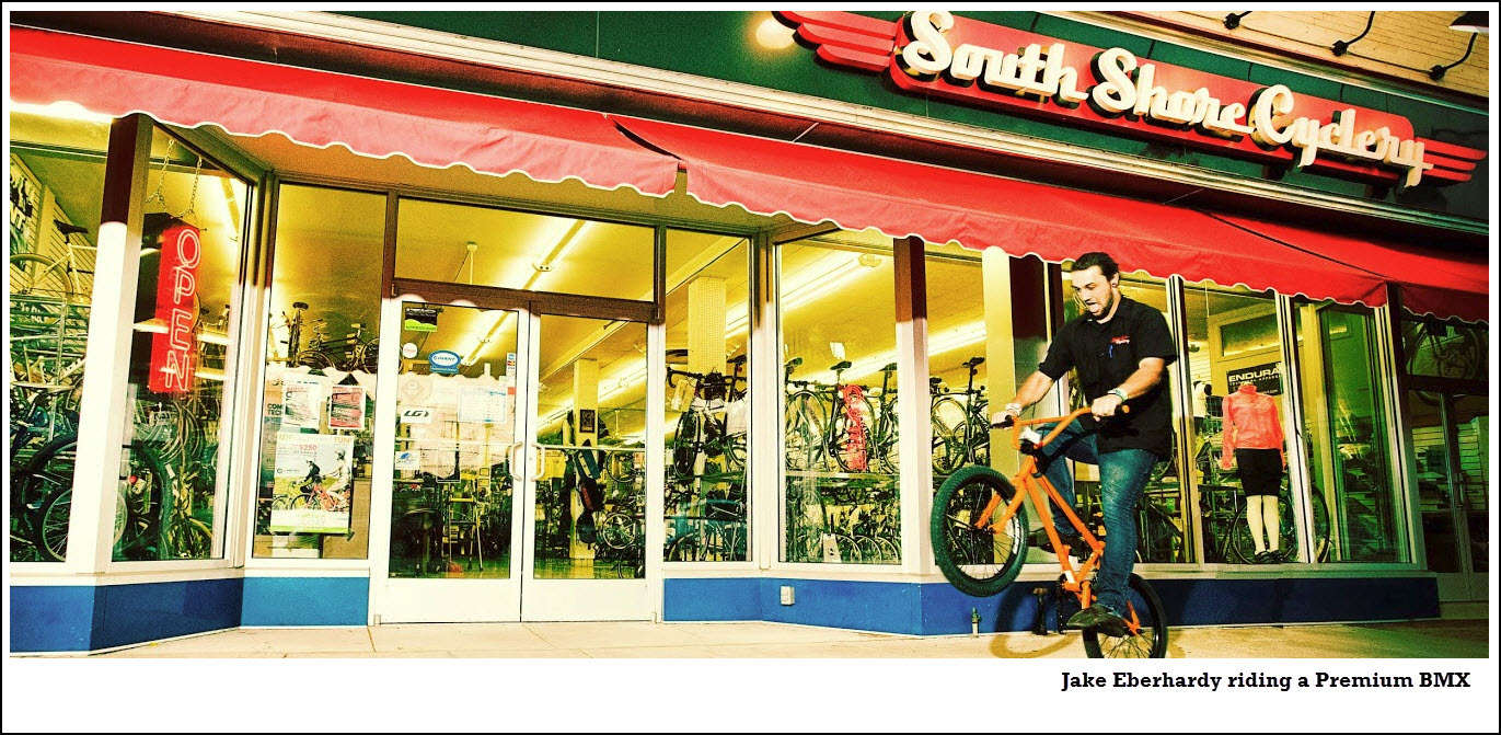Joe riding wheelie in front of store