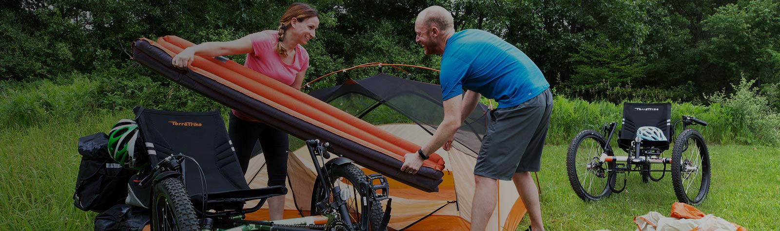 Couple settin up tent bike packing on terra trike recumbents
