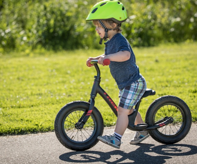 Toddler riding a balance bike.