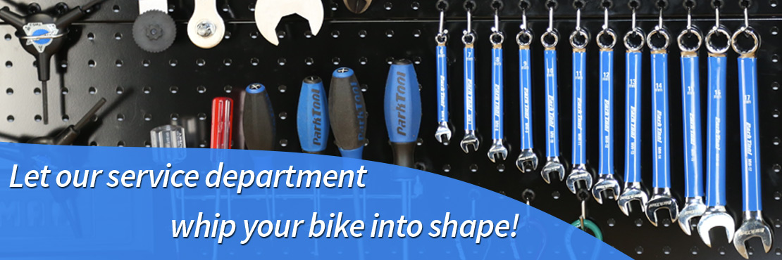 Wrenches and other tools hanging on a pegboard wall.