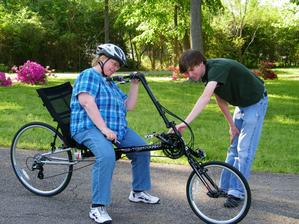 Employee showing recumbent rider some bike features