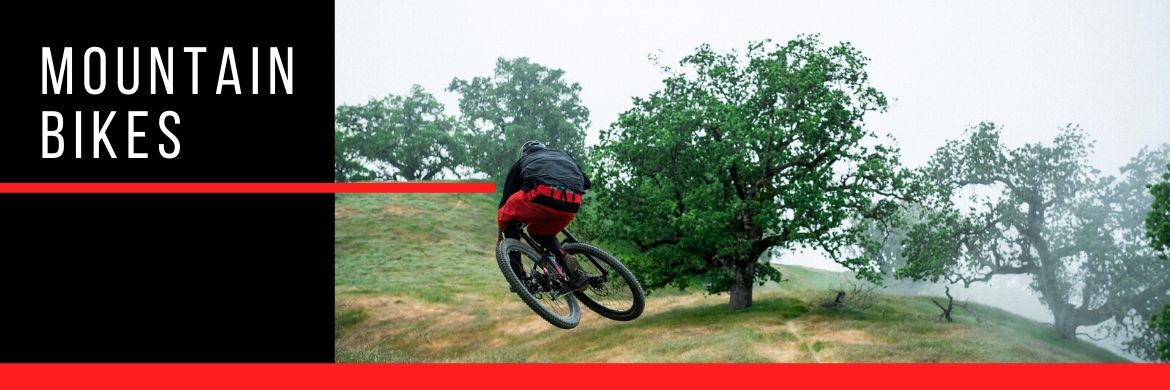 Person jumping a mountain bike on a trail