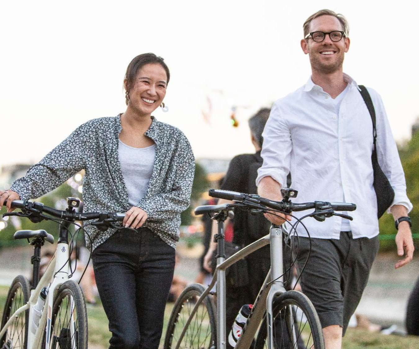 Image of two people walking their hybrid bikes