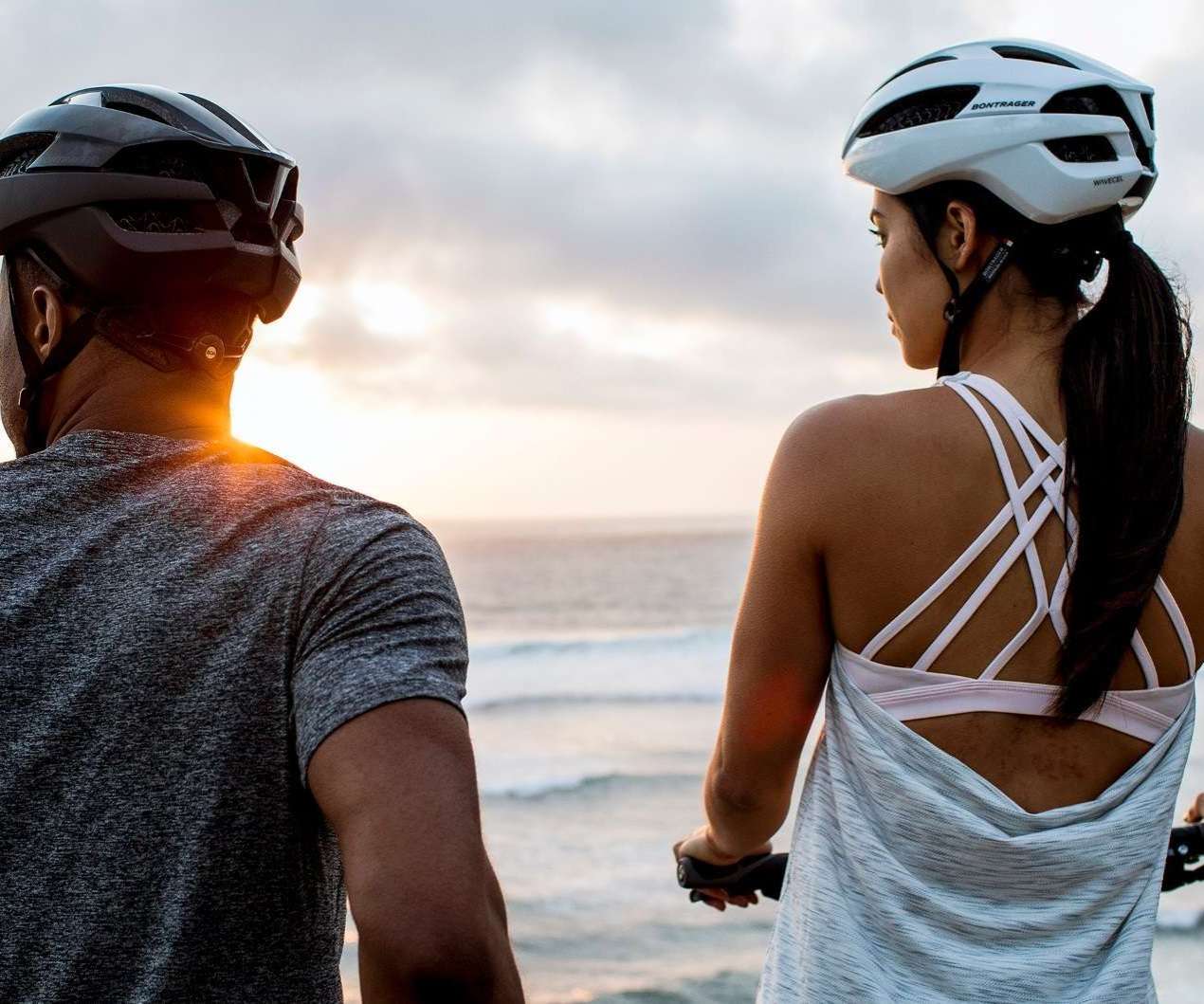 Image of two people on their hybrid bikes, by the ocean