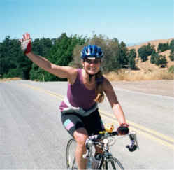 Woman waiving hello while riding her bike