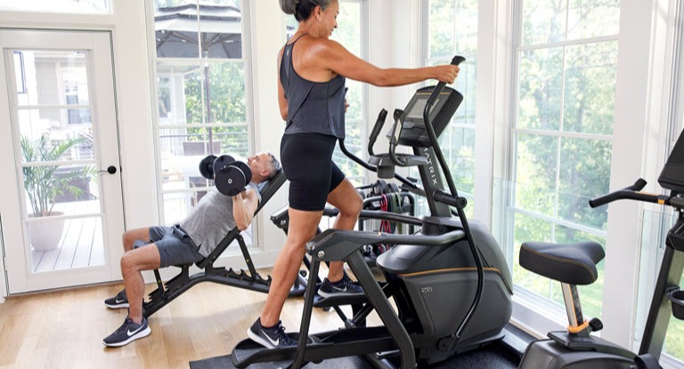Two people working out on fitness equipment