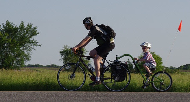 cyclist riding with a child on a trail a bike