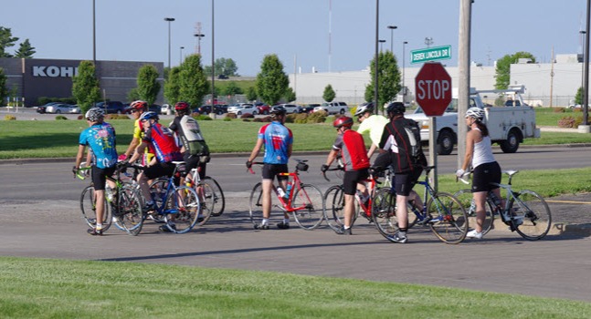 group of cyclists at a stop sign