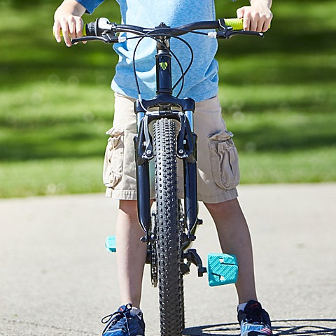 boy standing over a bike