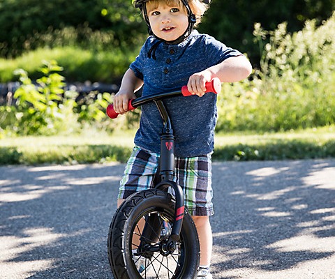 boy standing over a push bike
