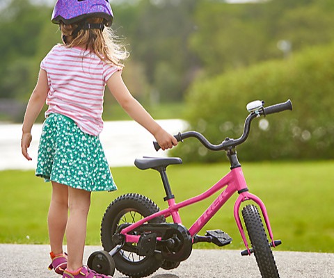 girl standing next to a bike