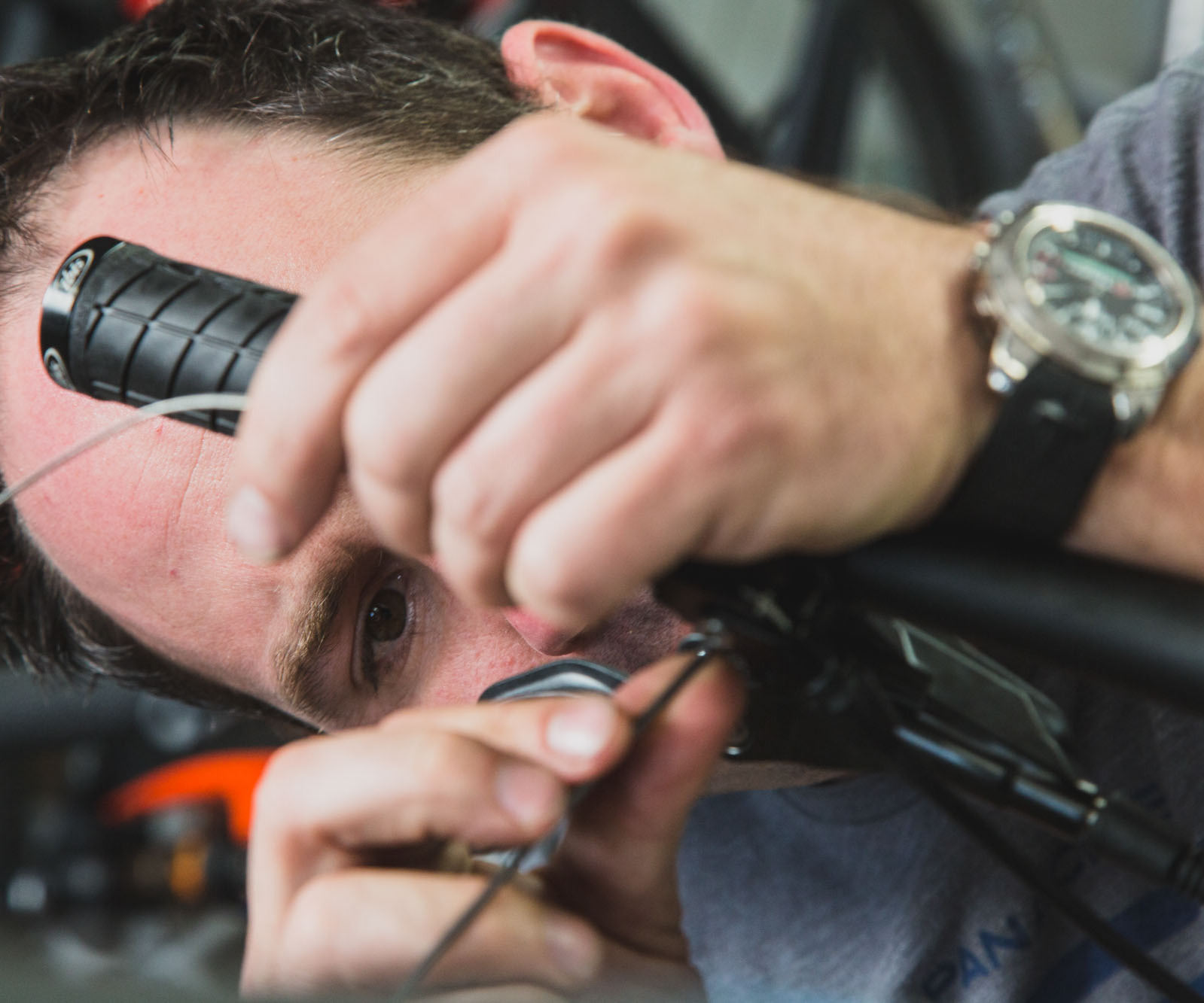 A close-up of a man fixing the brakes on a bike.