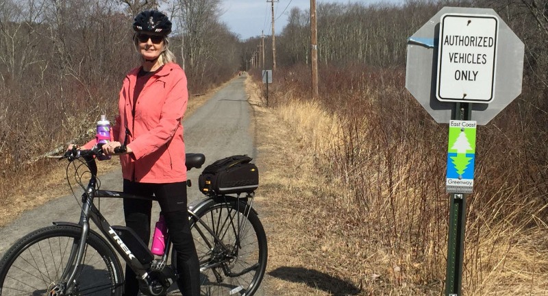 Ellen riding her Trek e-Bike on a paved trail