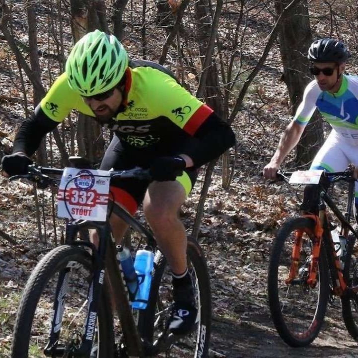 People racing mountain bikes in the woods