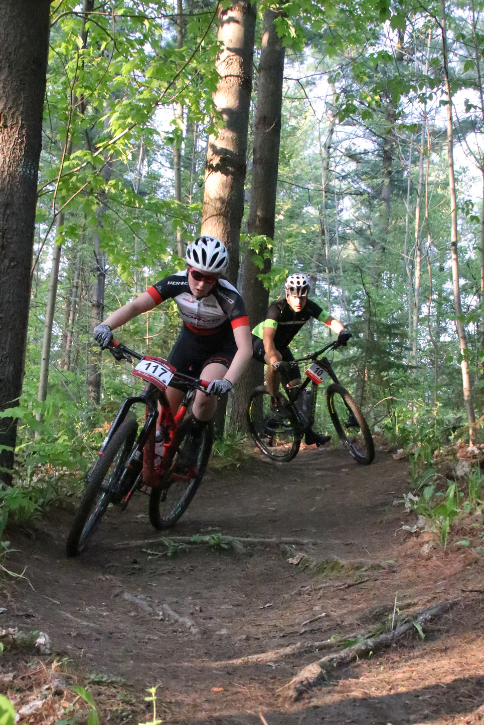 Carys Reid and Paul Boken rip through some immaculately groomed singletrack. Pursuing.