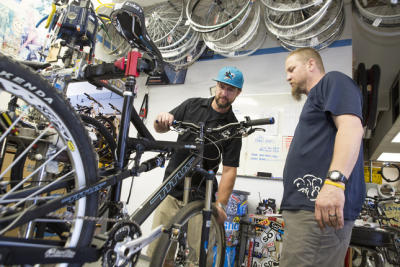 Bill Hyland, Jr. (left), works on a bike with employee Tim Bengard, at his family's business,