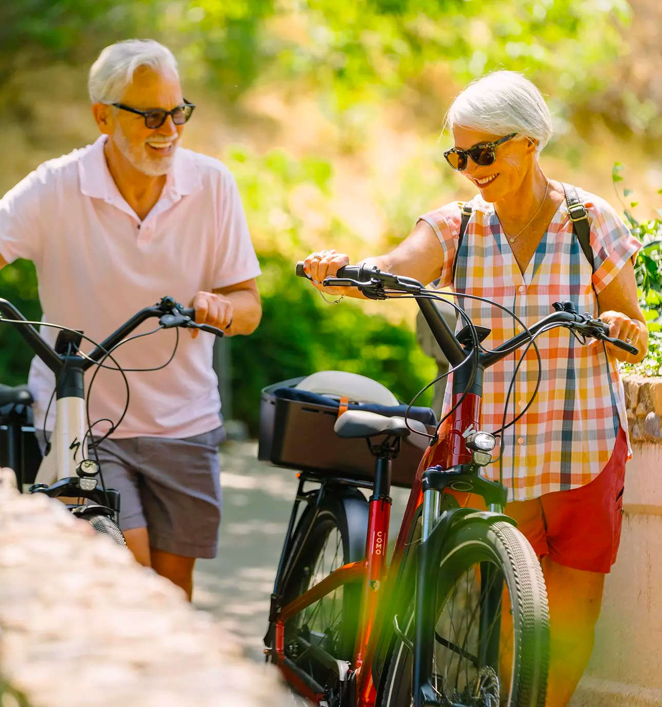 Two cyclists walking with e-bikes