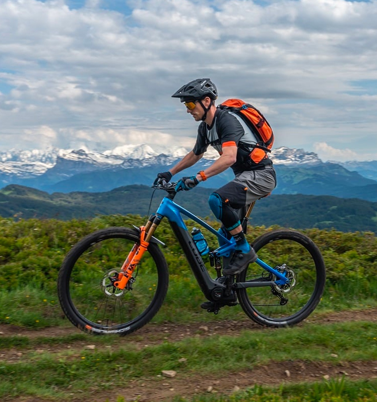 Cyclist riding e-mountain bike on dirt trail