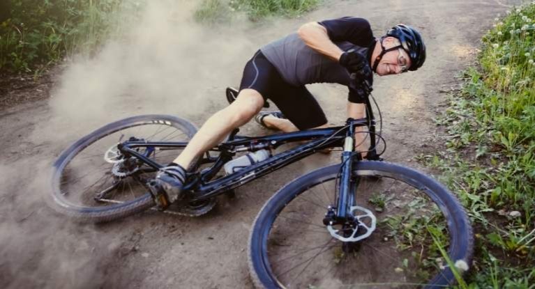 Man crashing a mountain bike.