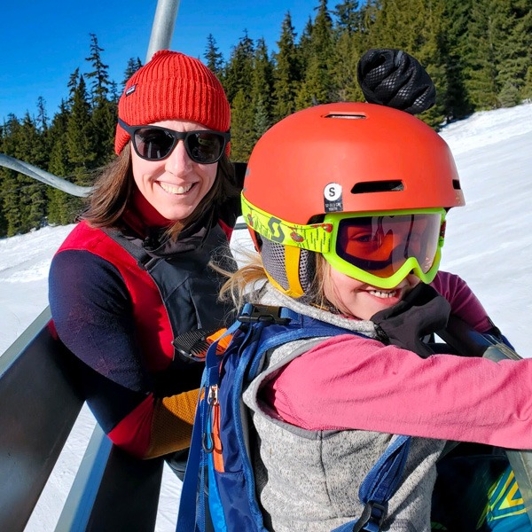 Woman and young boy in skiing gear on a ski lift
