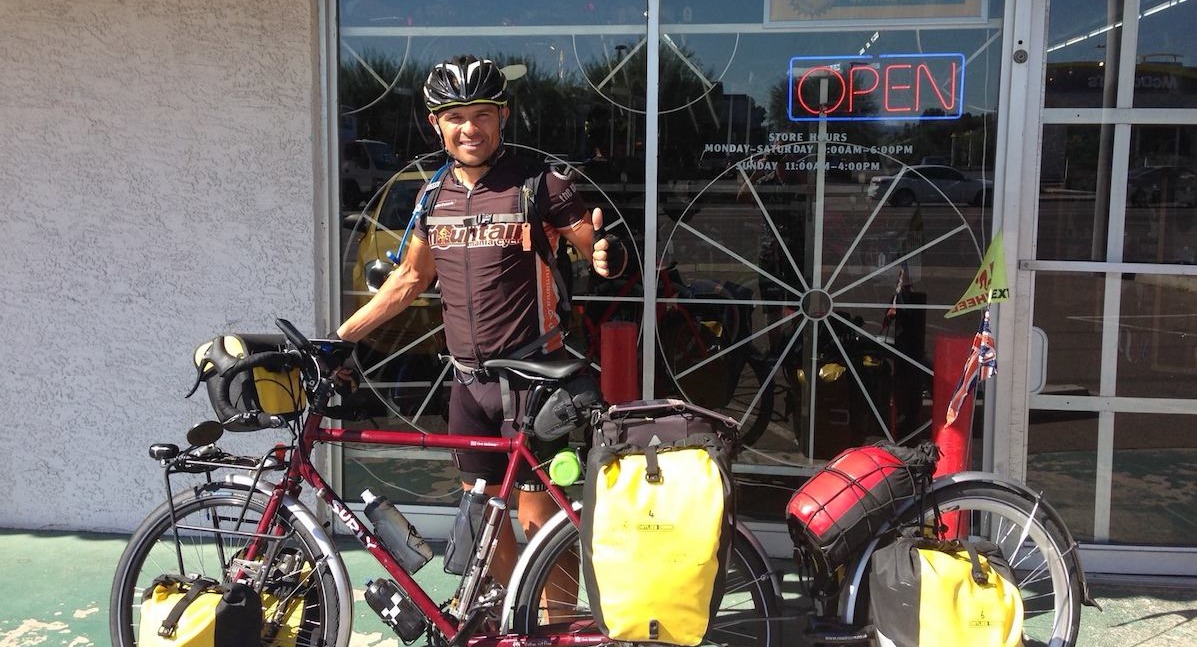 Cyclist with bike loaded up for an adventure