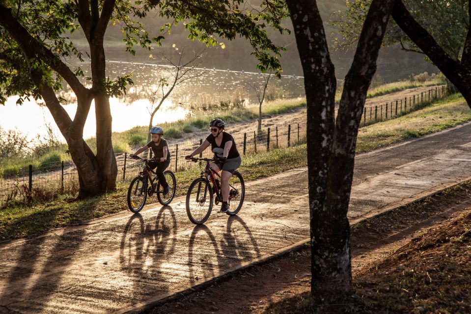 Image of two people riding bikes by a lake