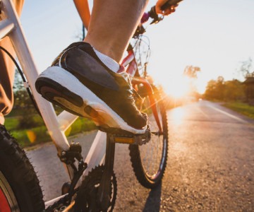 Person Riding a Bicycle on a Paved Trail