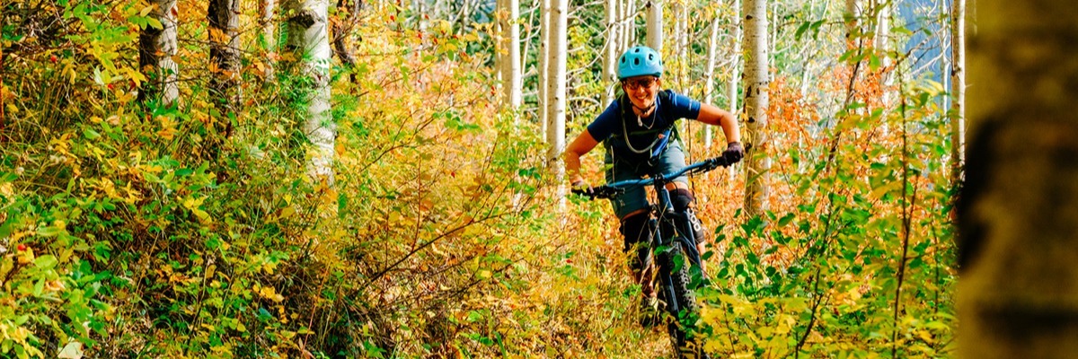 Image of a person riding their bike during the fall season