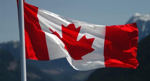 Canada's flag flies on a clear day