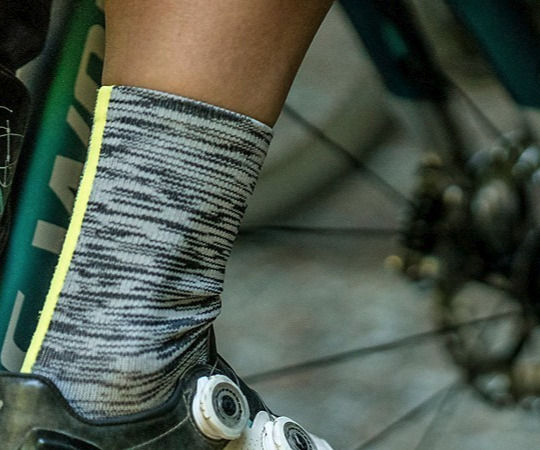 A close-up of a sock on someone's leg while pedaling