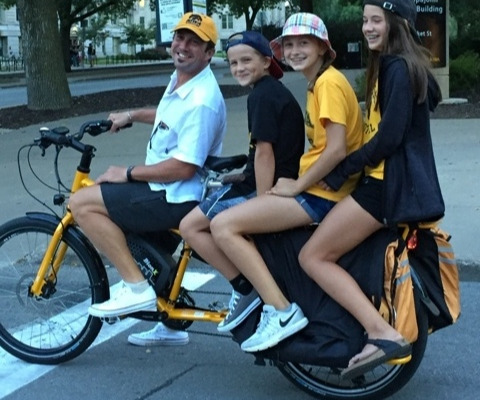 Four people riding on a cargo bike