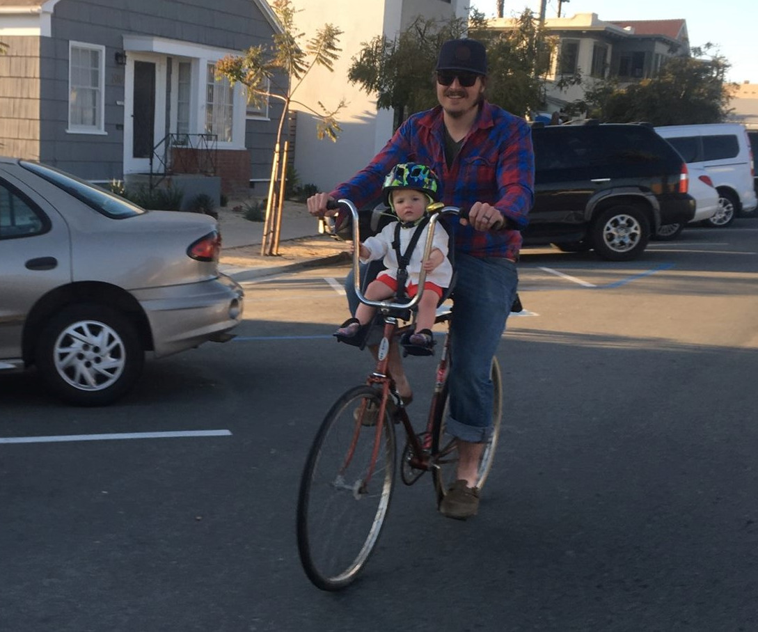 A father and his baby riding on a bike and seat-on bike