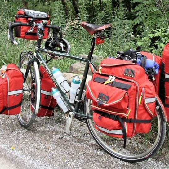 A road bike with multiple bags attached to it.