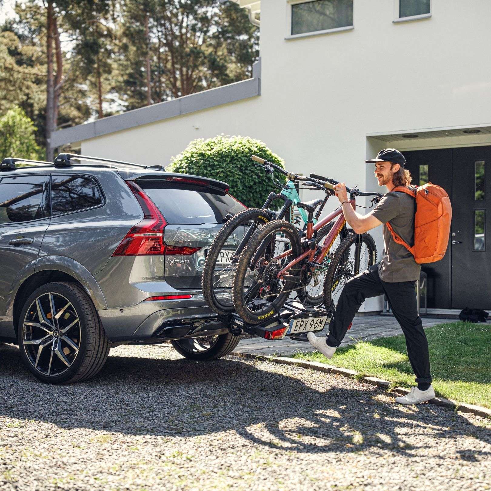 Image of person loading bikes on bike rack attached to car